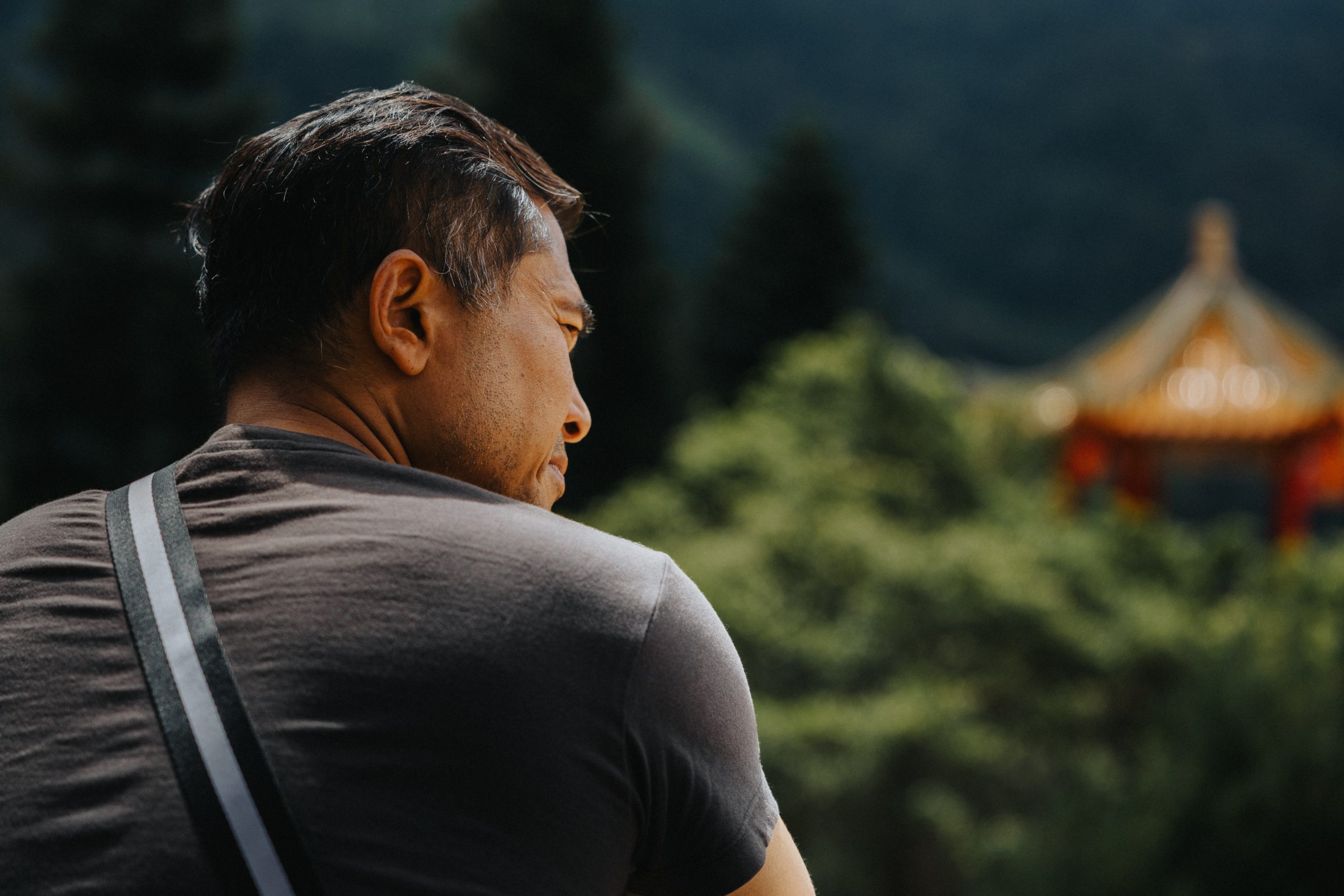 Man looking in the distance near to a Chinese Temple in Malaysia