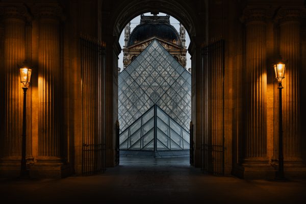 Interior of the Louvre with a grand arched doorway and tall Gothic style windows