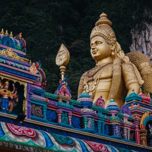 The colourful Hindu temple at Batu Caves in Malaysia, with the golden statue of Lord Murugan rising against the limestone cliffs.