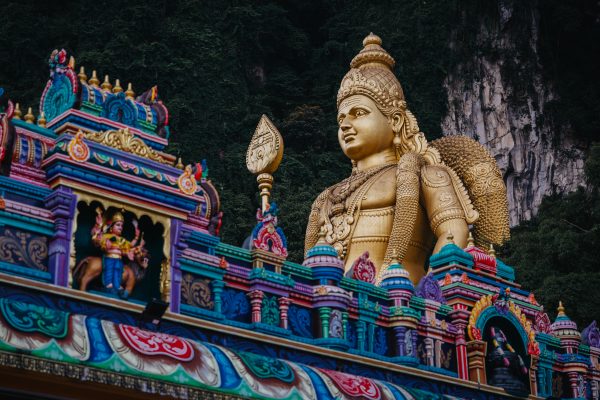 The colourful Hindu temple at Batu Caves in Malaysia, with the golden statue of Lord Murugan rising against the limestone cliffs.