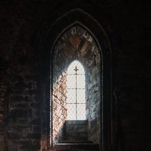 Gothic arched window illuminated by daylight inside St Davids Cathedral, Wales